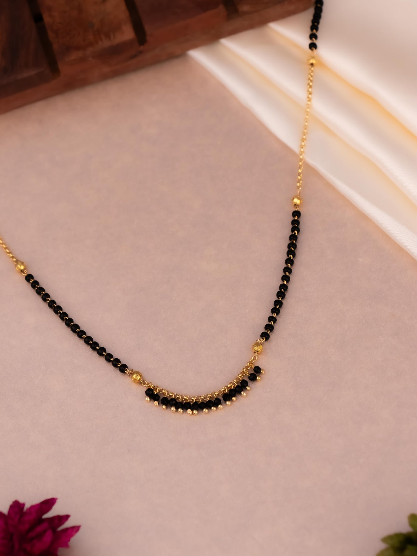 Traditional Single chain mangalsutra with black beads and gold polish.
