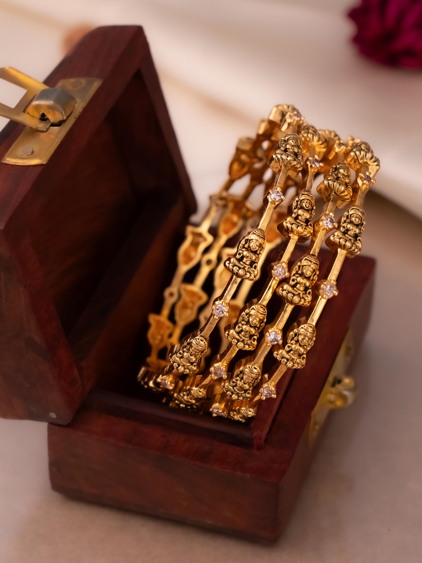 Beautiful temple jewellery bangles in antique Lakshmi design with white stones.

